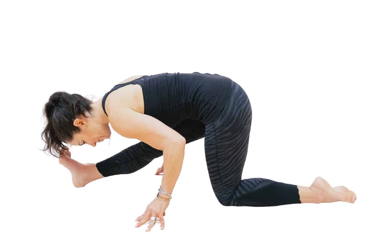 a picture of a woman wearing black yoga clothes doing half splits pose