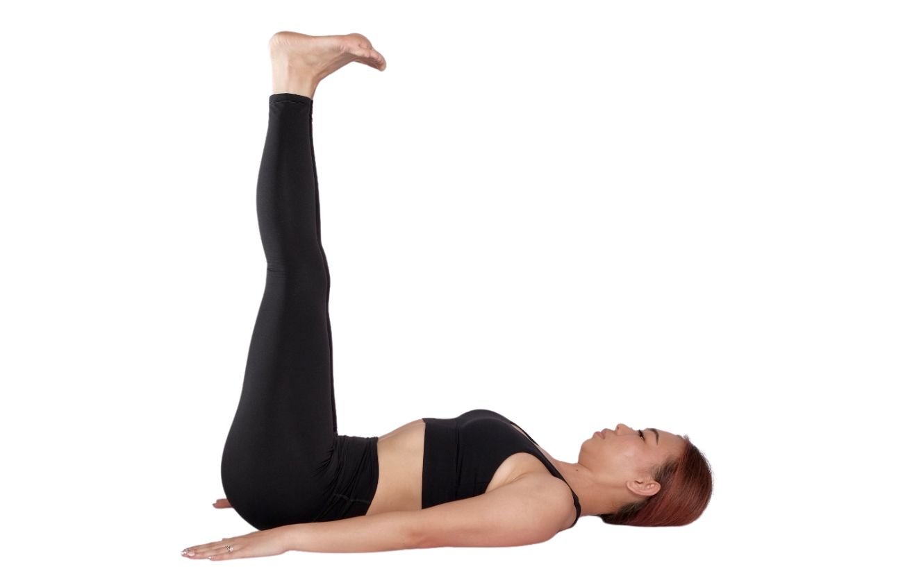 a woman wearing black yoga clothes in half plow pose