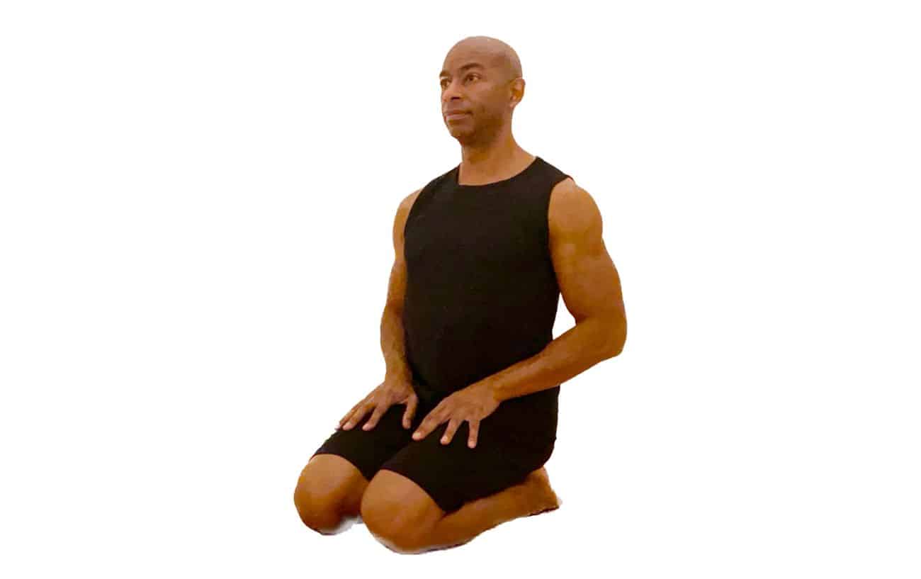 a man in black yoga clothes doing thunderbolt pose