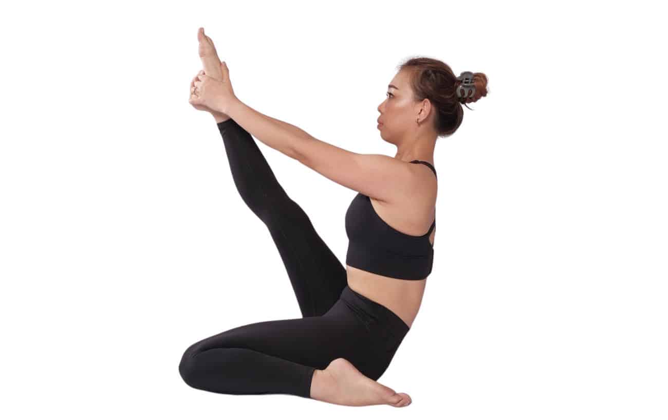 a woman wearing black yoga clothes doing heron pose