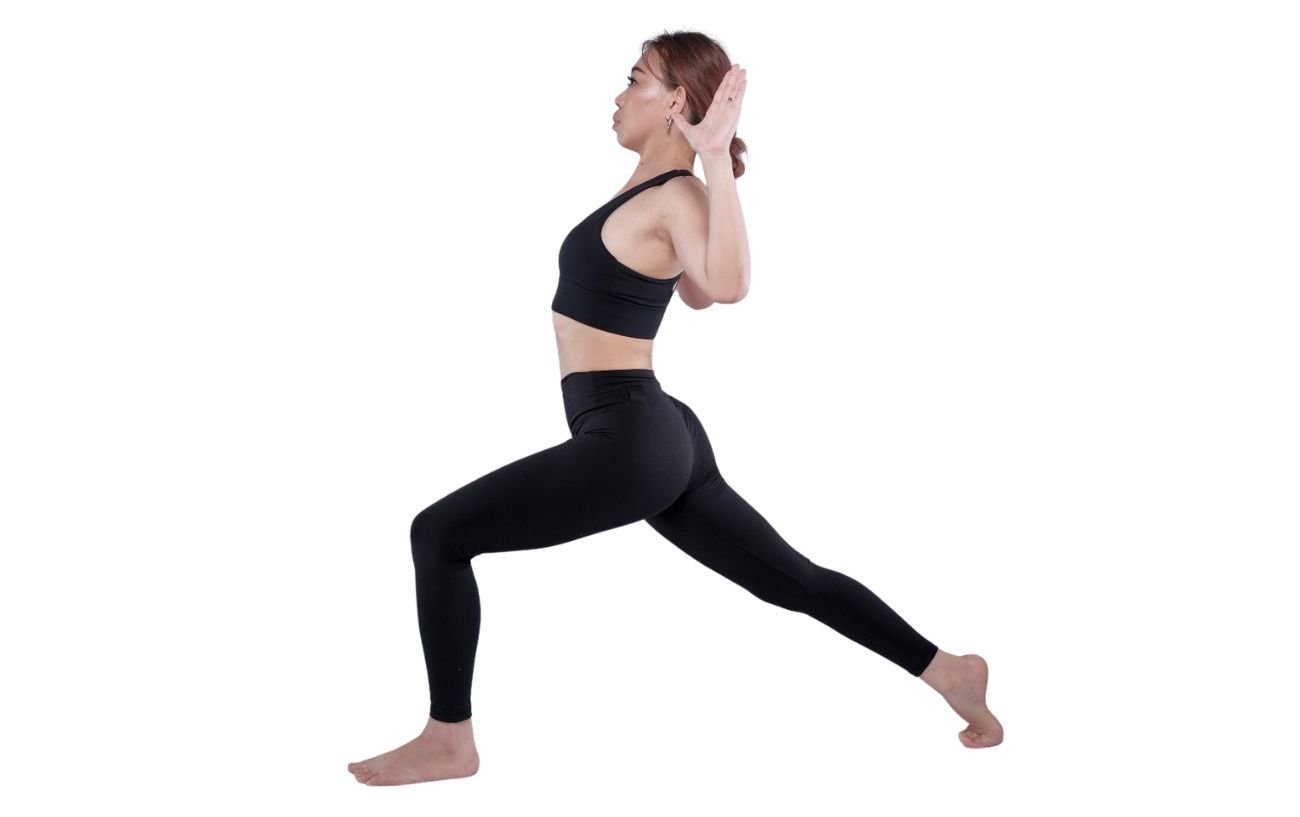 a woman wearing black yoga clothes doing a high lunge with cactus arms