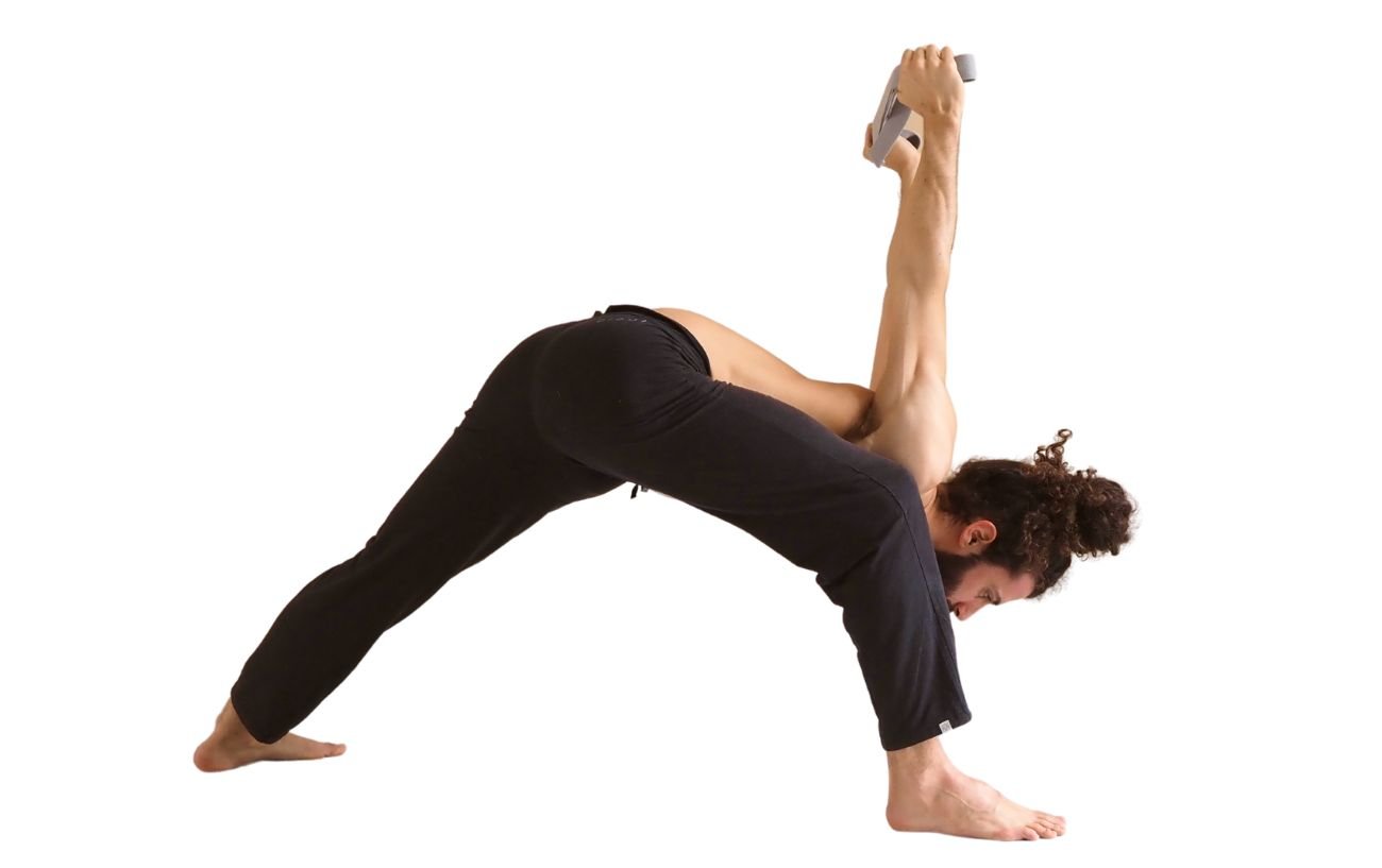 a man wearing black yoga trousers doing humble warrior pose with a strap