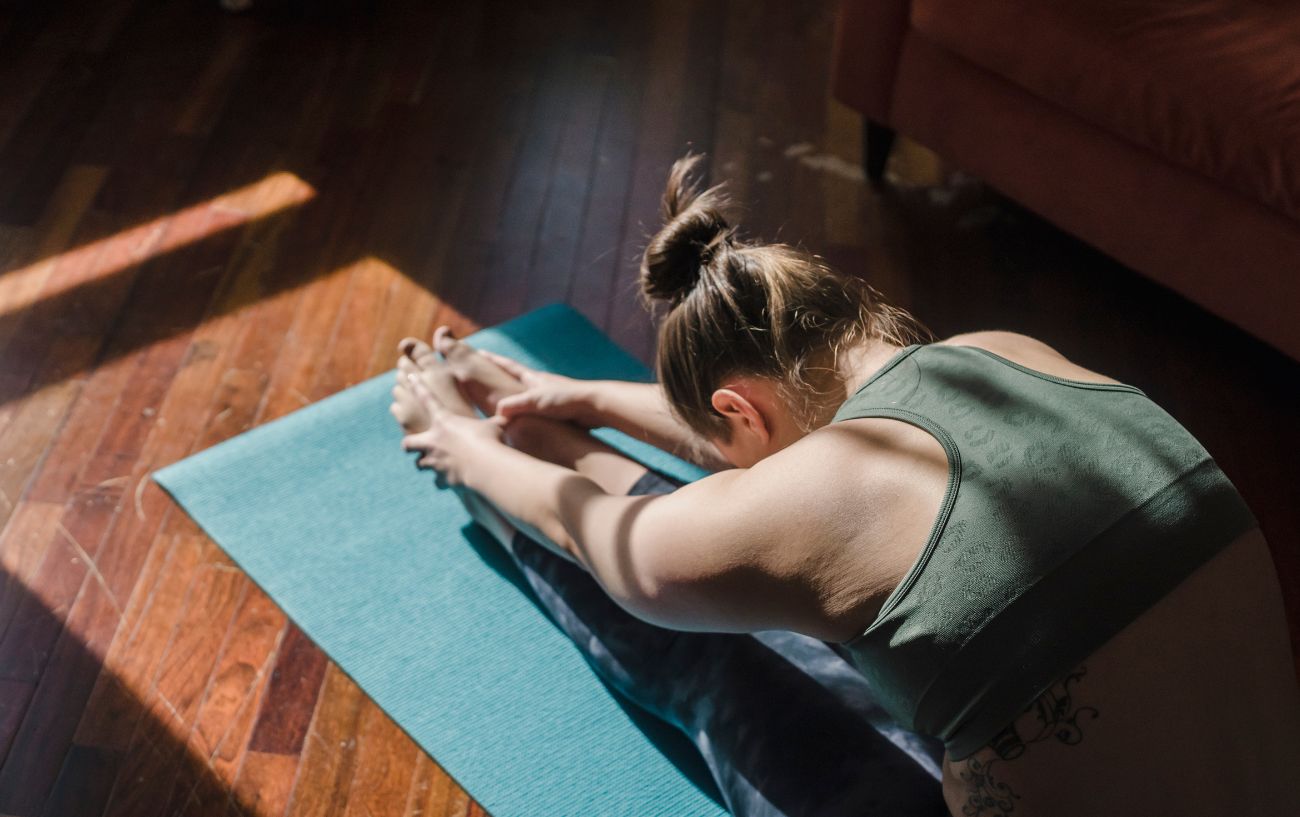 A woman sitting in a forward fold.