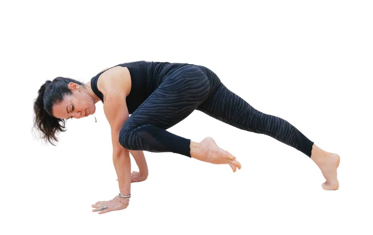 a woman doing knee to elbow plank pose in yoga