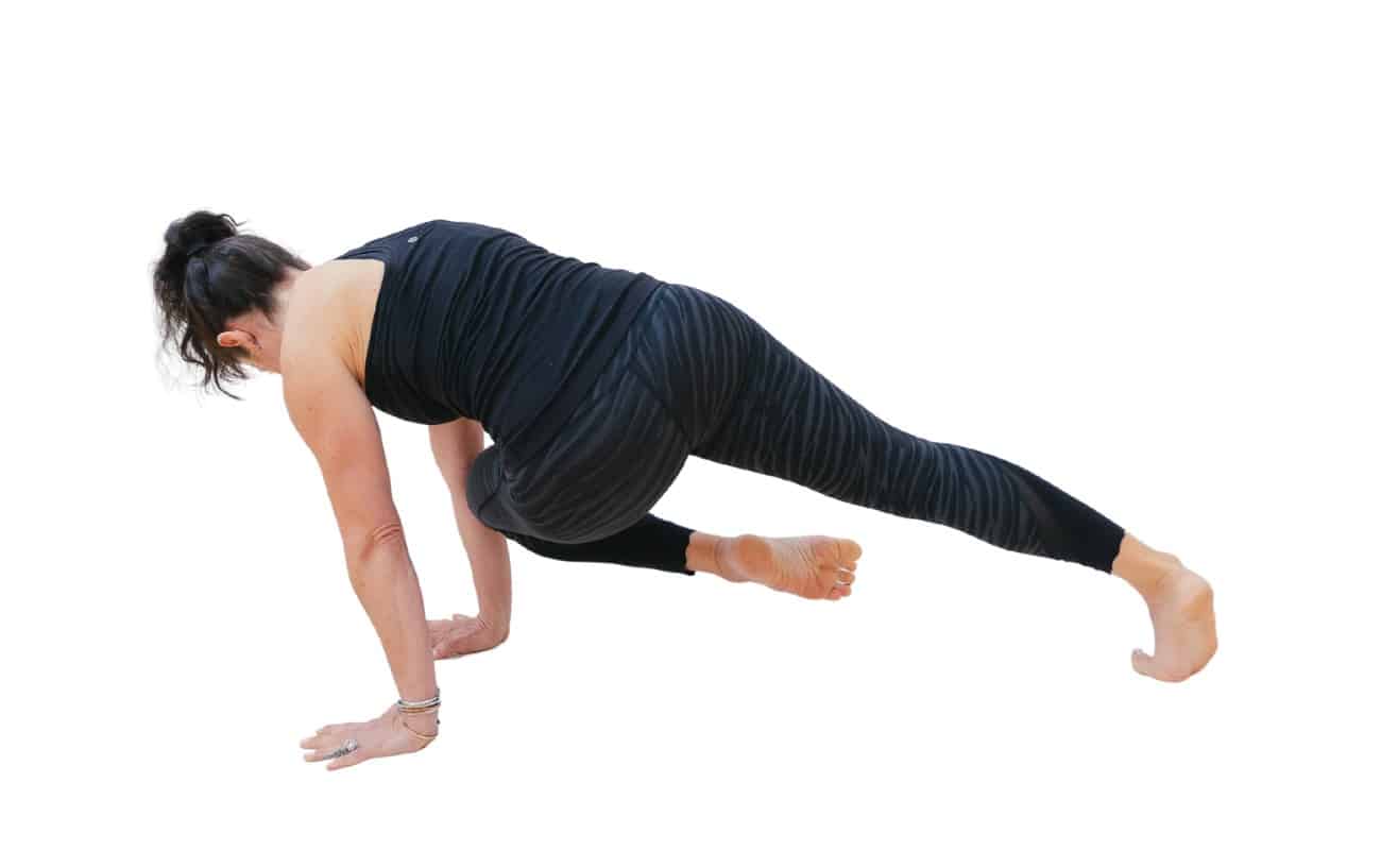 woman performing a yoga knee to opposite elbow plank with her back turned