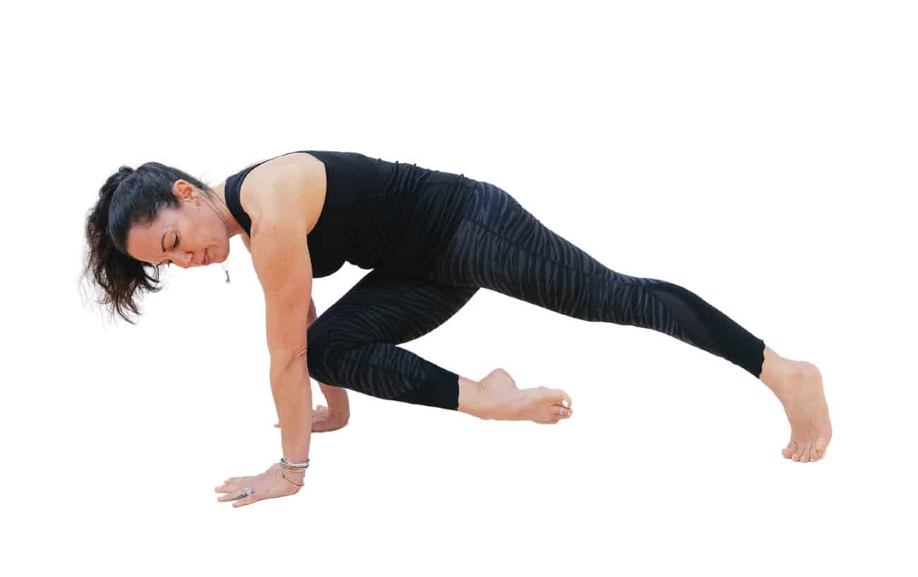 a woman practicing knee to opposite elbow plank yoga pose