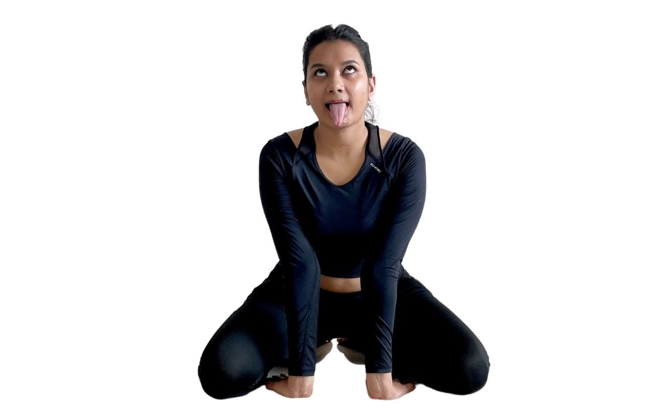 a woman wearing black yoga clothes doing lion pose