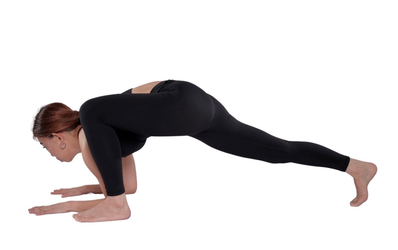 a woman wearing black yoga clothes doing lizard pose