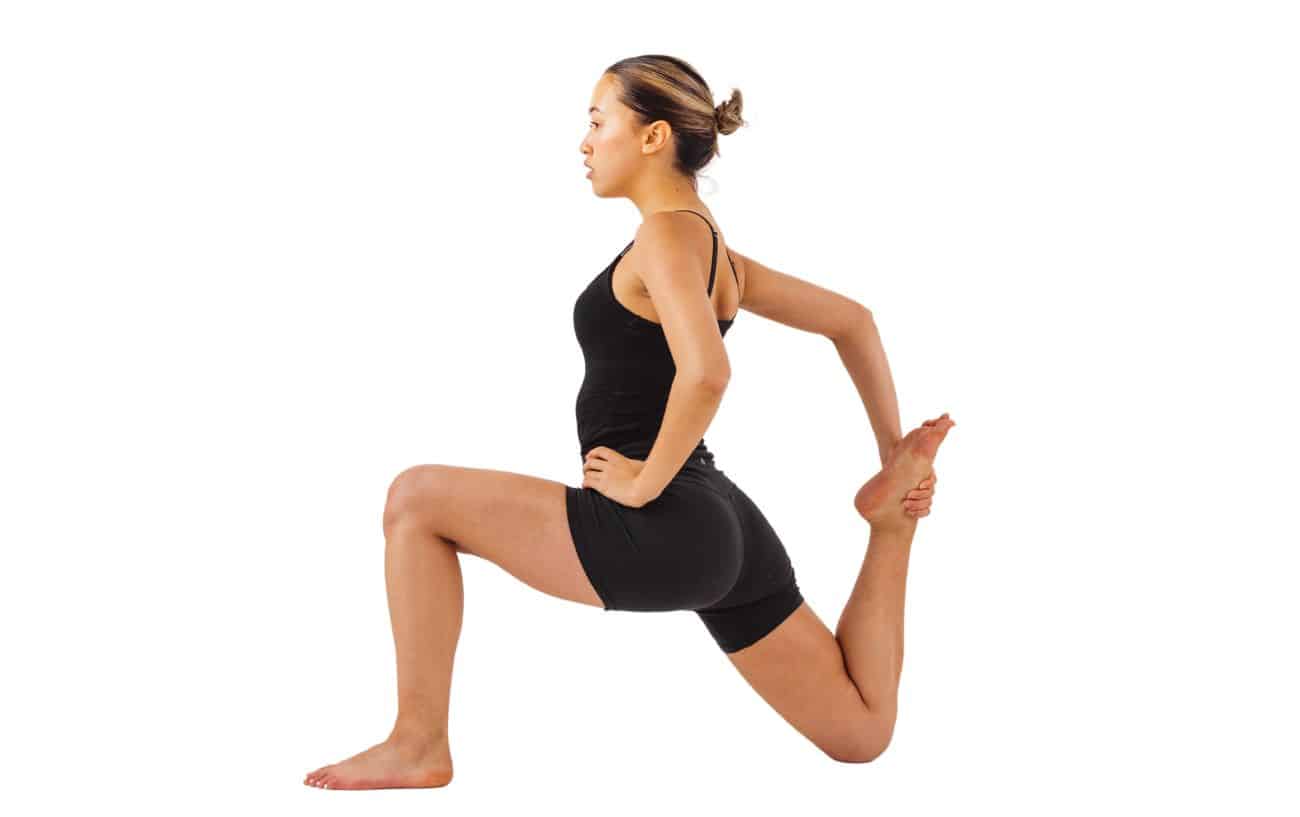 a woman wearing black yoga clothes doing reclined low lunge pose with a quad stretch