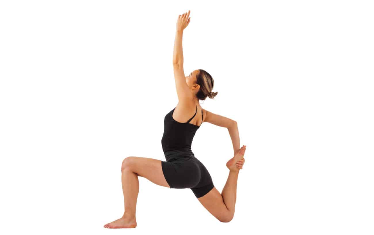 a woman wearing black yoga clothes doing reclined low lunge pose with a quad stretch and a raised arm