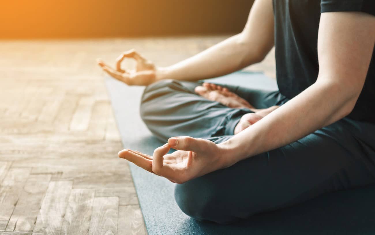 man sits in cross legged meditation