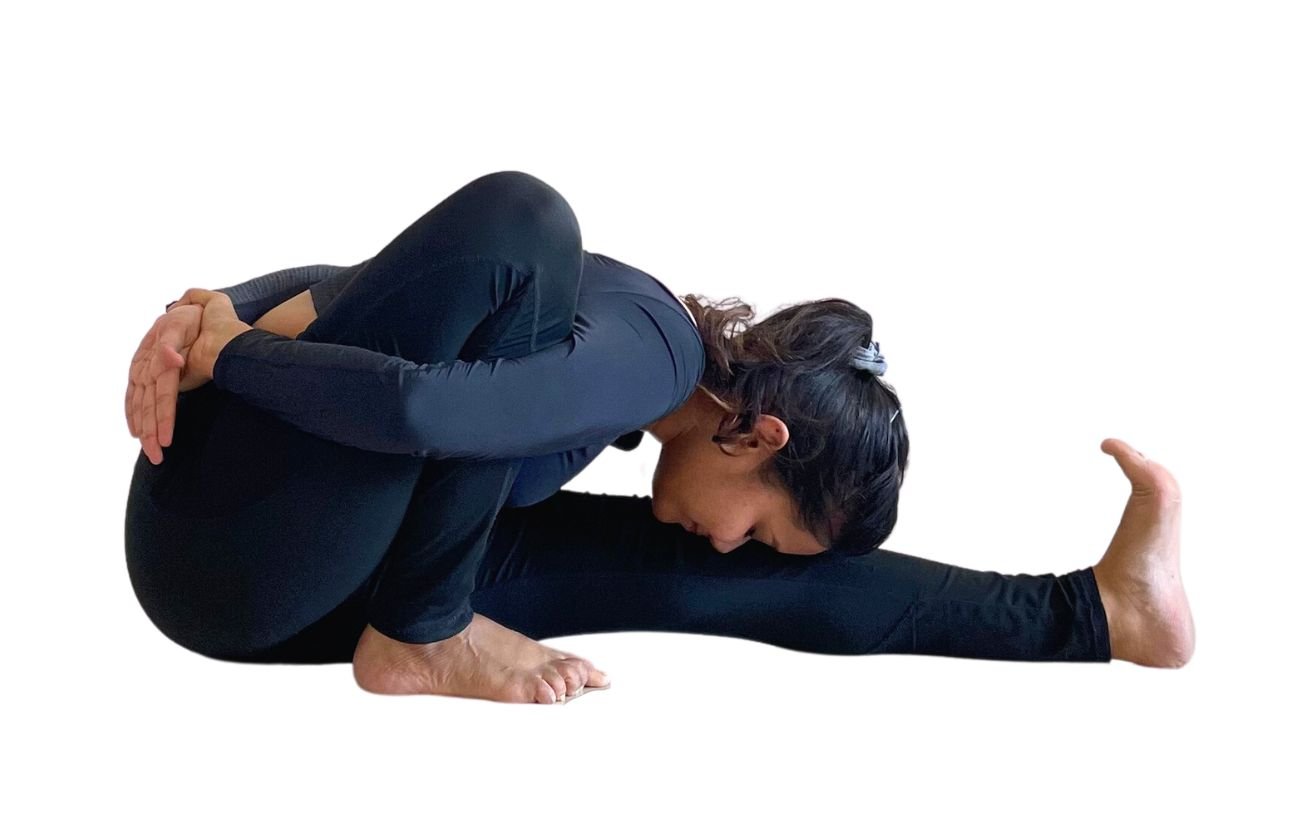 a woman wearing black yoga clothes doing Marichyasana a