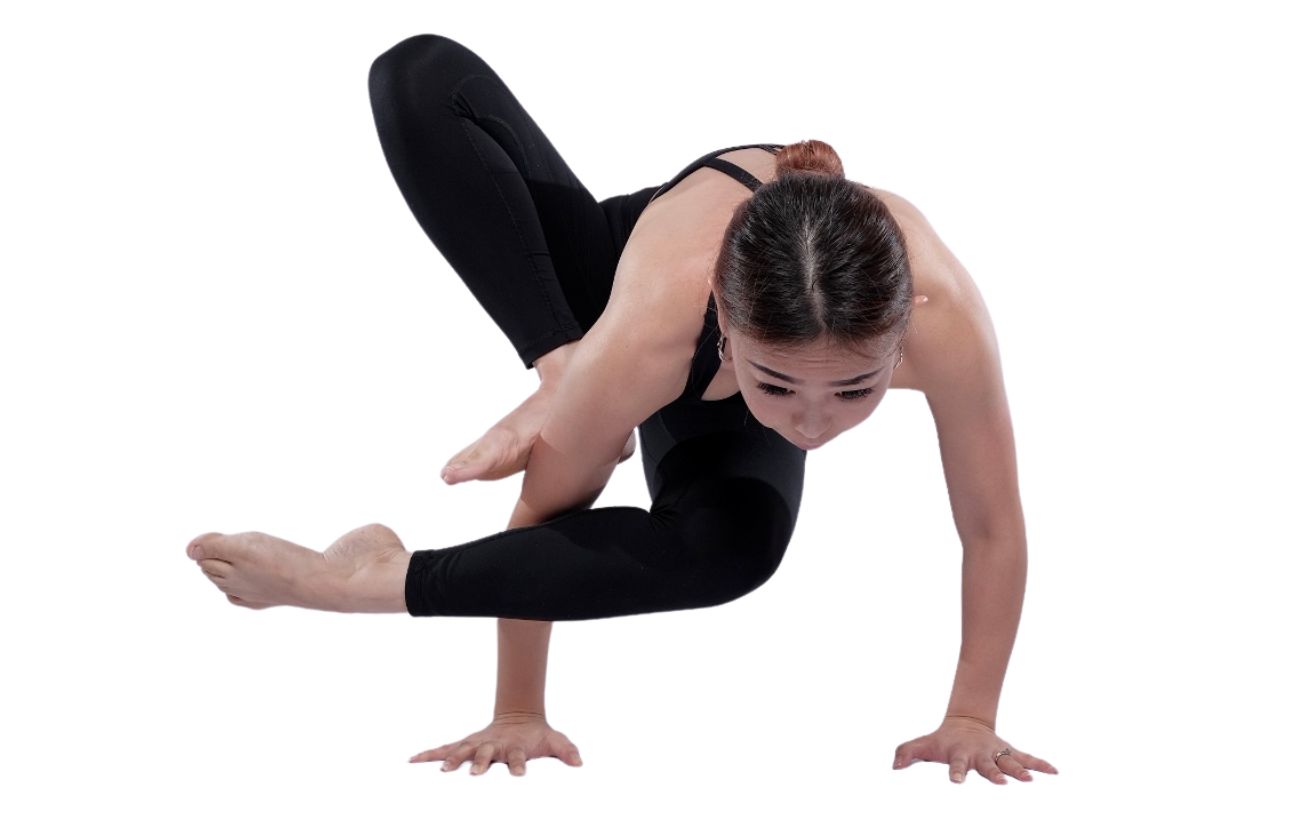 a woman wearing black yoga clothes doing mating grasshopper pose