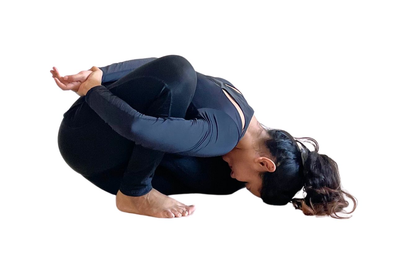 a woman wearing black yoga clothes doing Marichyasana B