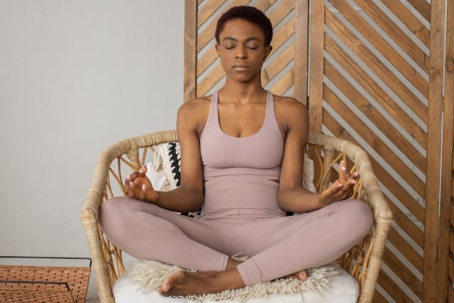 a woman meditating in a chair