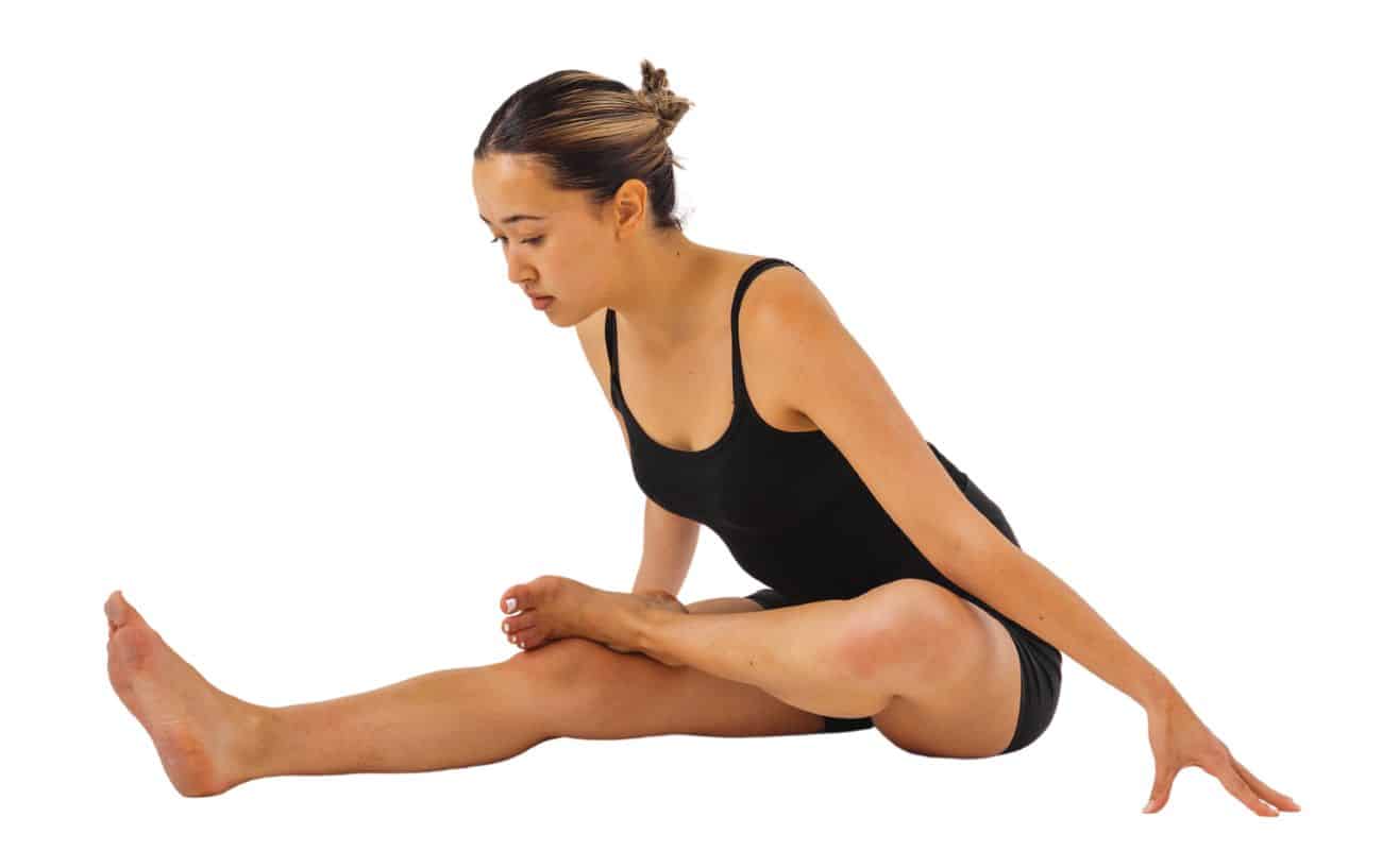 a woman wearing black yoga clothes doing fire log pose with one leg extended