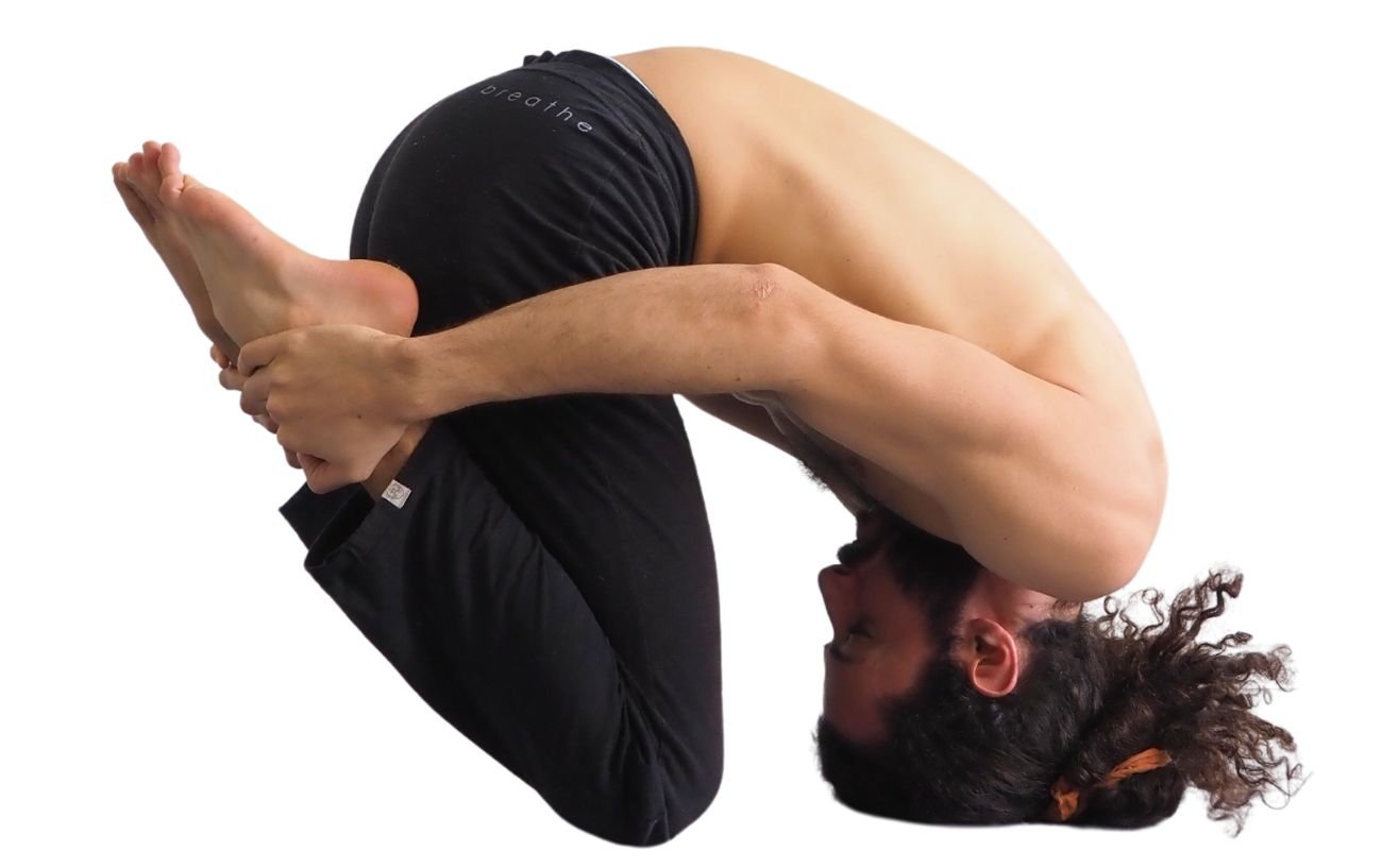 a photo of a man in black yoga pants doing rabbit pose with his heels to his buttocks