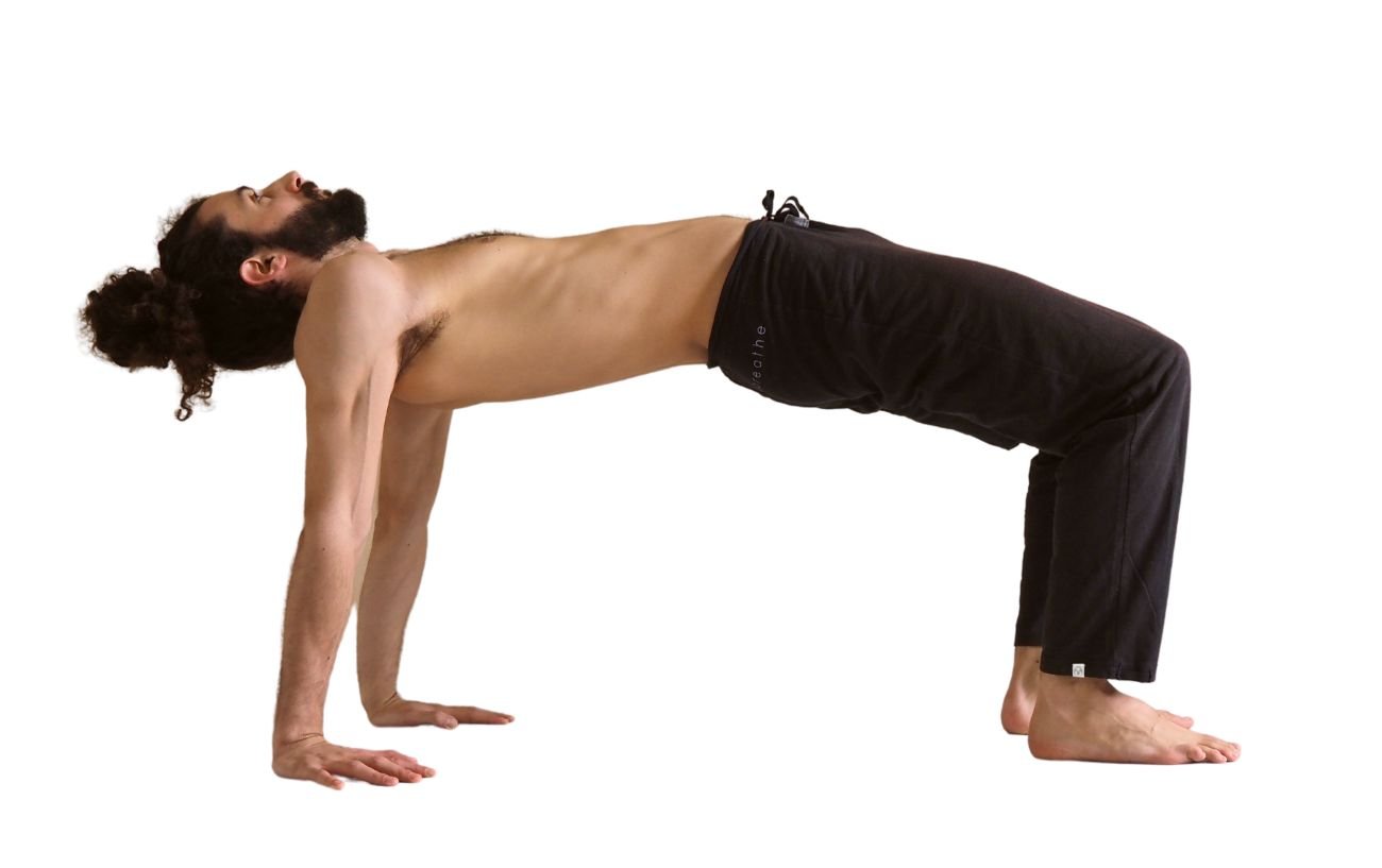 a man wearing black yoga trousers doing reverse tabletop pose