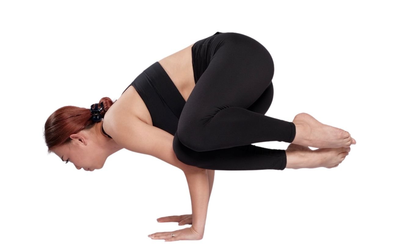 a woman wearing black yoga clothes in side crow pose/ side crane pose