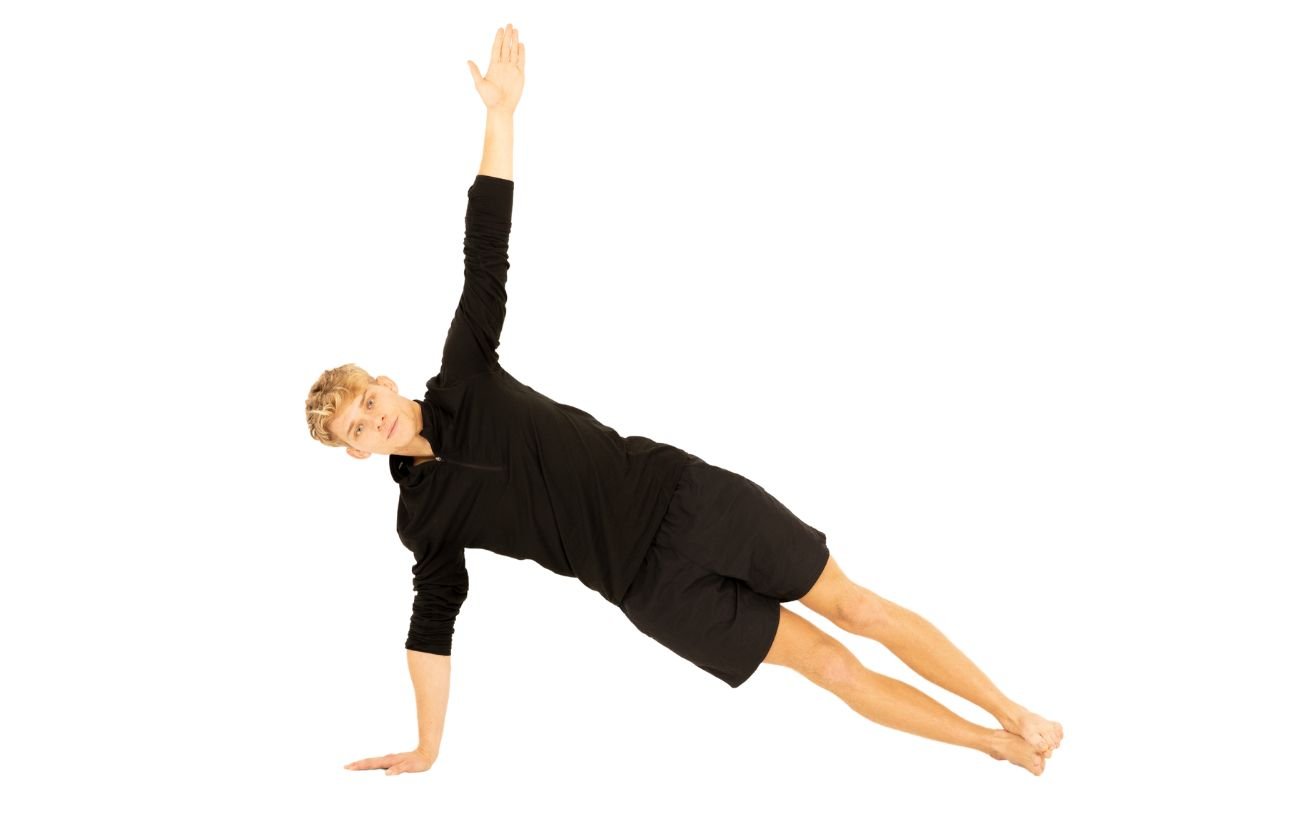 a man in black yoga clothes doing side plank pose