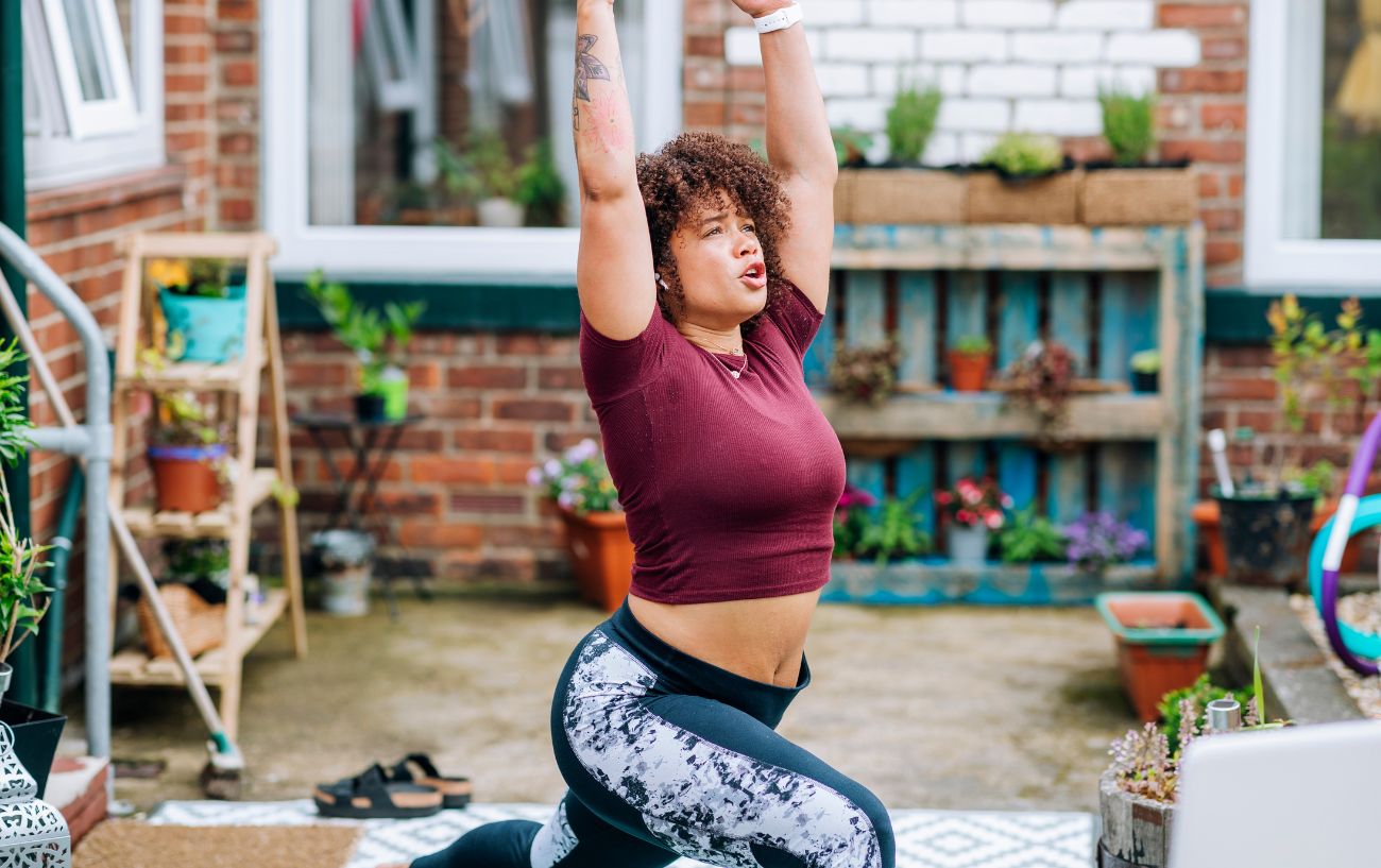 a woman doing sun salutation b in her garden