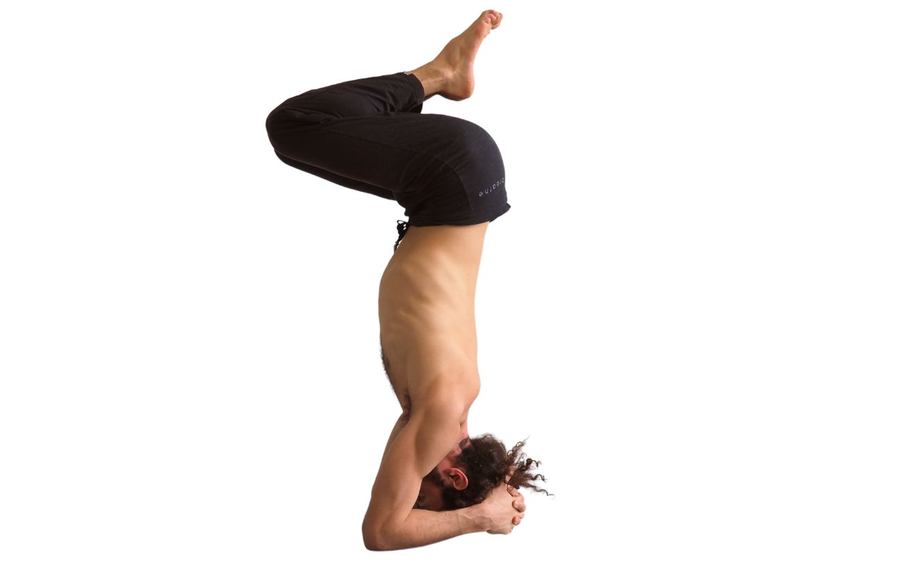 a man doing supported headstand with bent knees