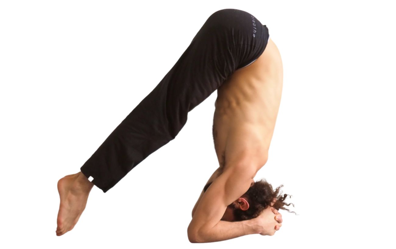 a man doing supported headstand prep yoga pose