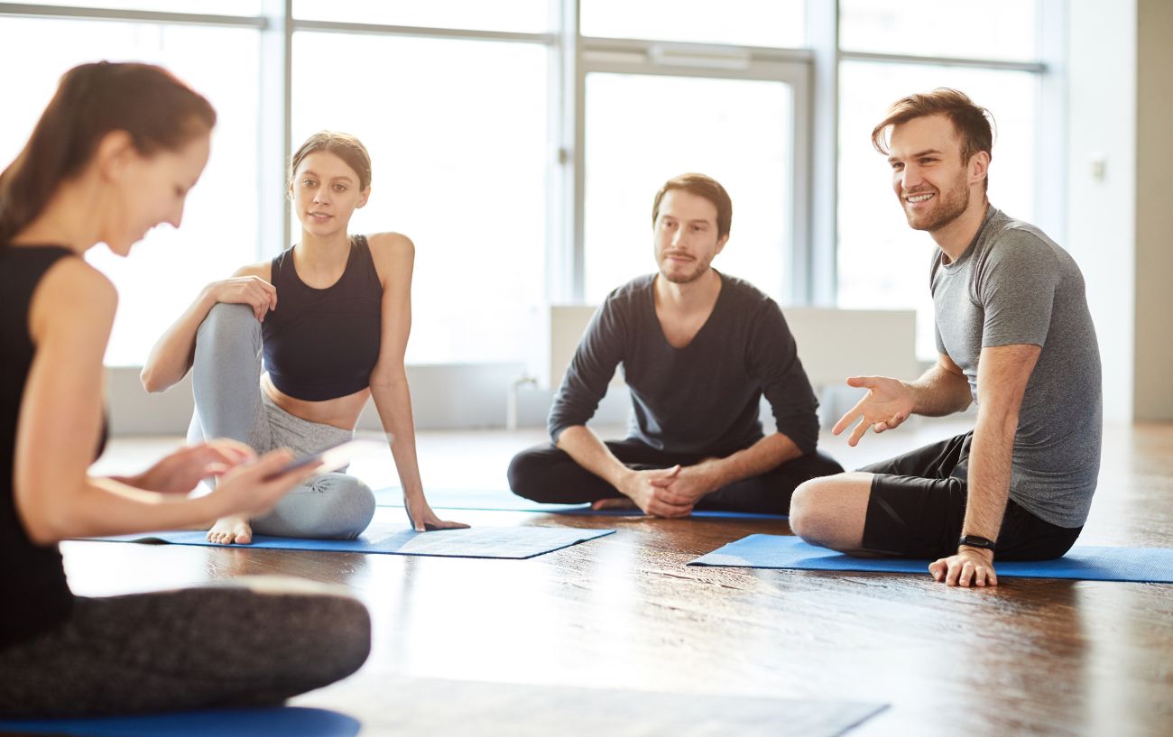 A group of four yoga students talking