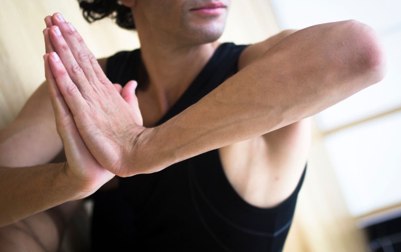 a man doing yoga with his hands in prayer