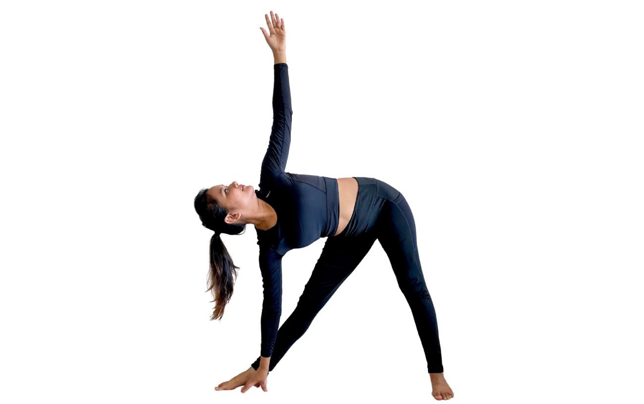 a woman wearing black yoga clothes doing triangle pose