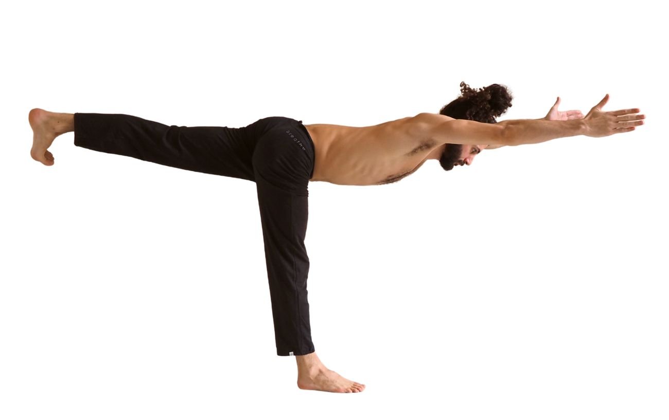 a man wearing black yoga trousers doing warrior 3 pose