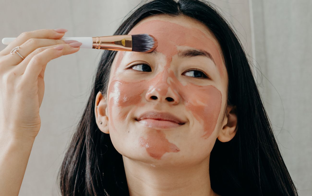 a woman painting on a face mask