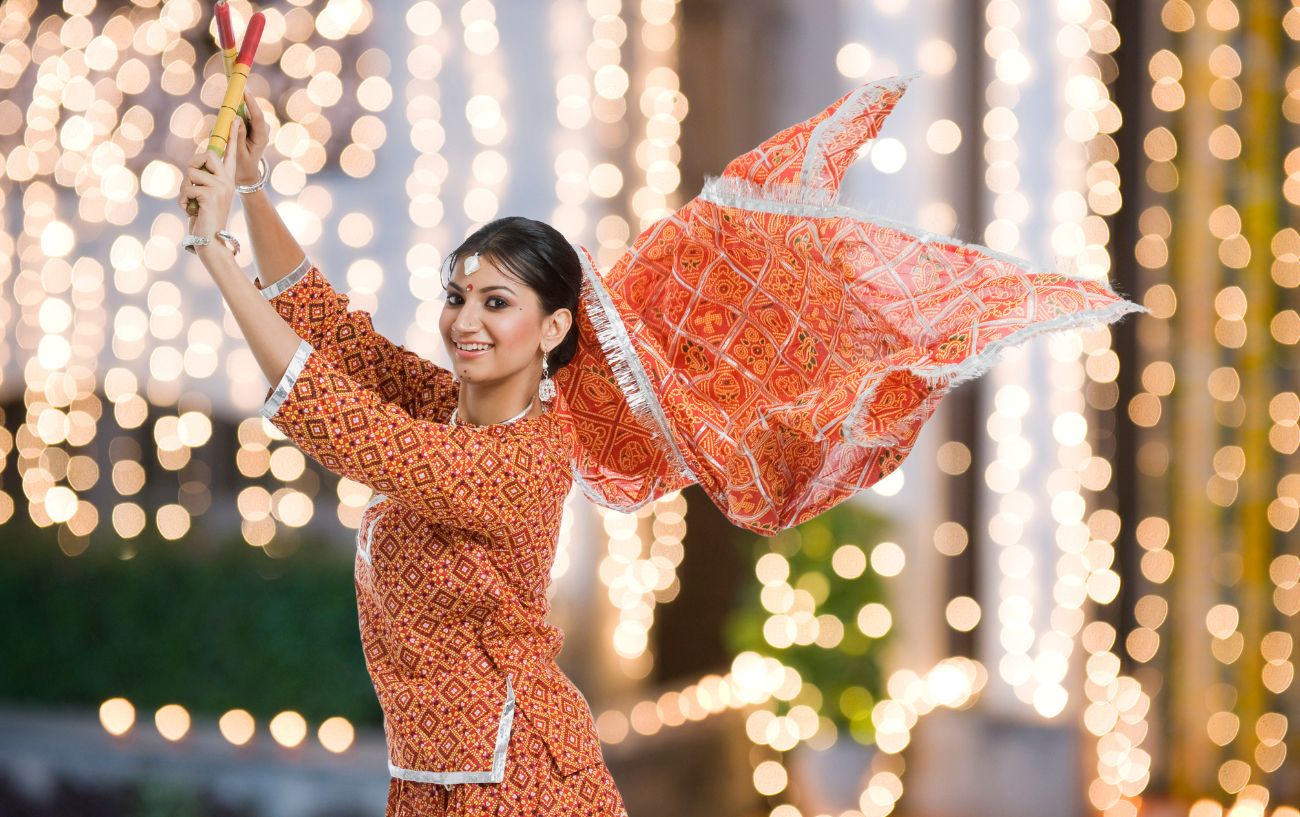 A woman in red dancing garba. 