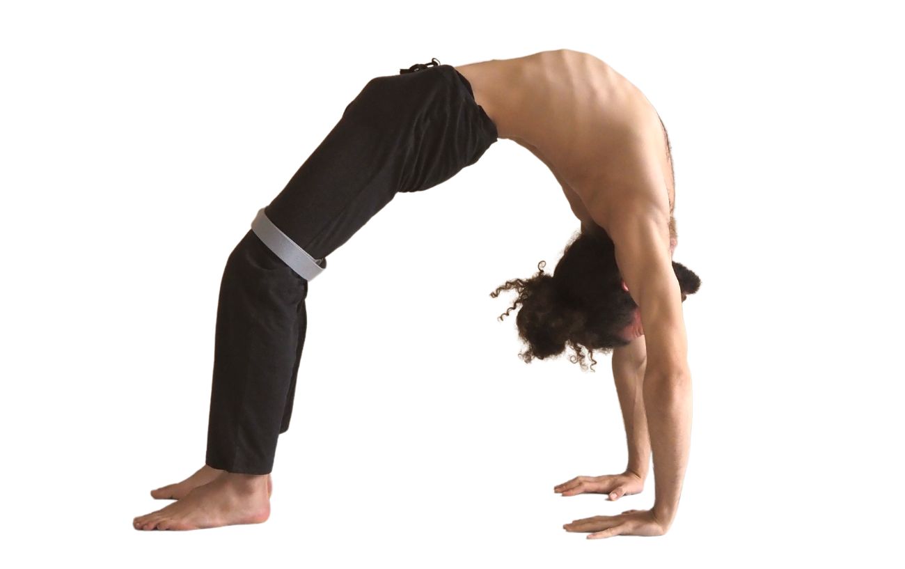 a man wearing black yoga clothes in wheel pose with a strap around his thighs