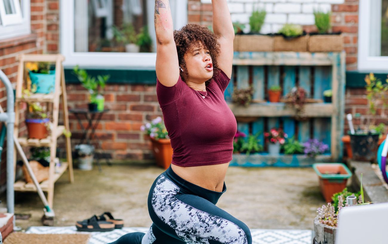 woman doing warrior pose in her garden