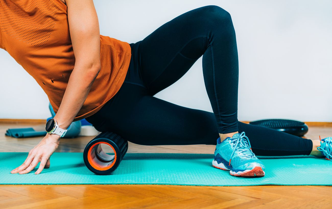 a woman foam rolling her it band