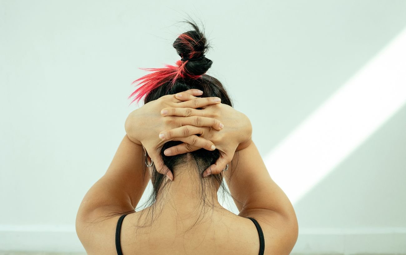 a woman doing a yoga for neck and shoulders stretch