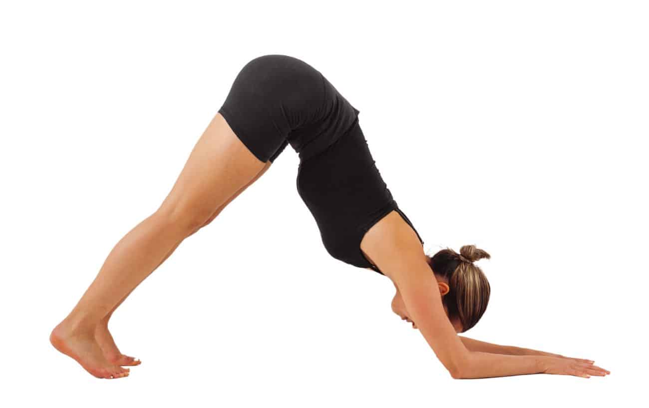 a woman wearing black yoga clothes doing dolphin pose